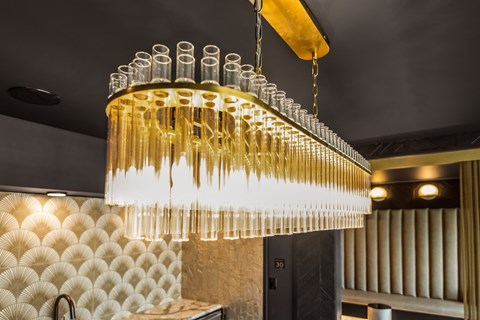 a chandelier made of champagne glasses hangs from the ceiling