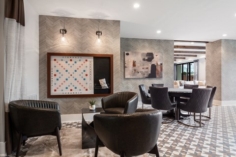 a room with a table and chairs and a quilt on the wall