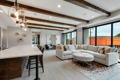 a spacious living room with a large couch and a kitchen with a breakfast bar