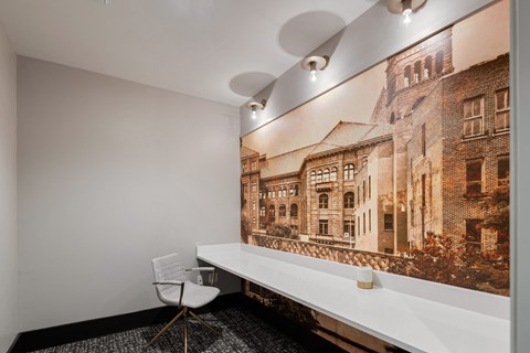 a white desk and chair in a room with a large picture on the wall