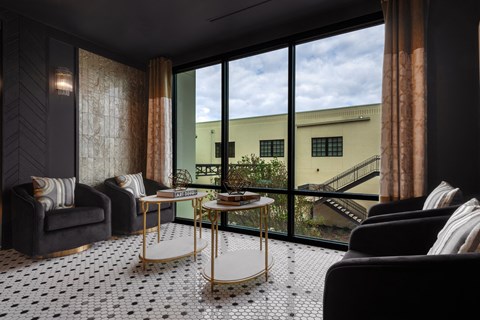 a living room with a large window and a black and white tile floor