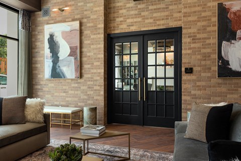 a living room with a black door and a brick wall