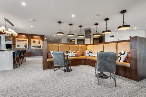 a seating area with chairs and a bar in the middle of a room