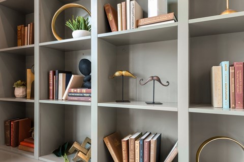 a bookcase with books and a lamp