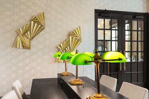 a dining room with a black dining table and green lamps