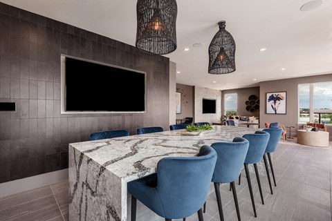 a long table with blue chairs and a large television on the wall