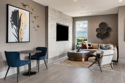 a living room with a couch table and chairs and a flat screen tv on the wall