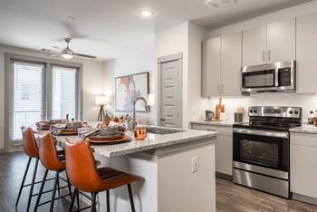 A modern kitchen with a dining table set for four.