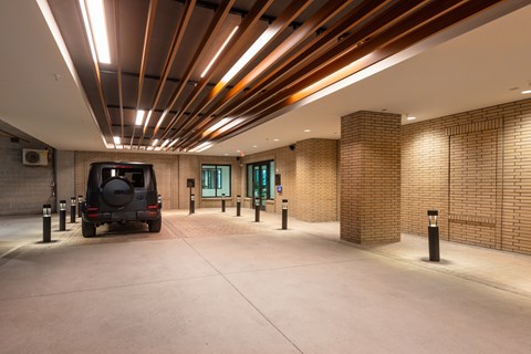 A car is parked in a garage with brick walls and ceiling.