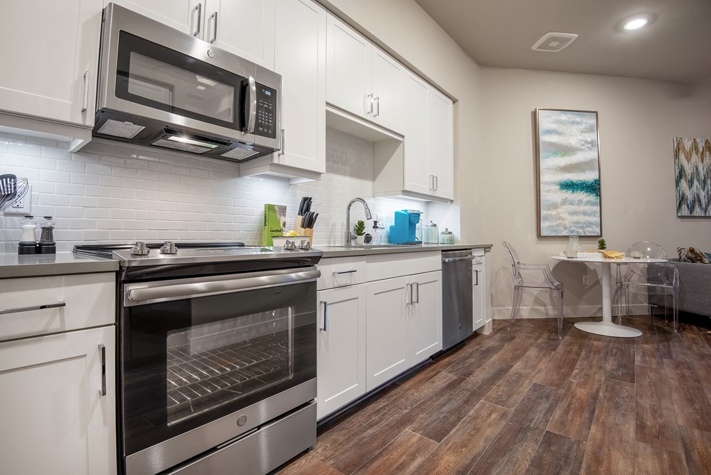a kitchen with white cabinets and stainless steel appliances  at Encore at Boulevard One, Denver, 80230