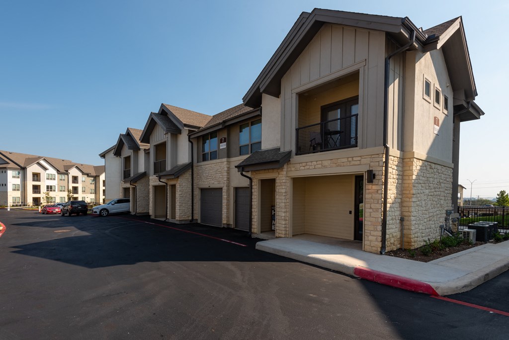a row of town homes with balconies and a parking lot