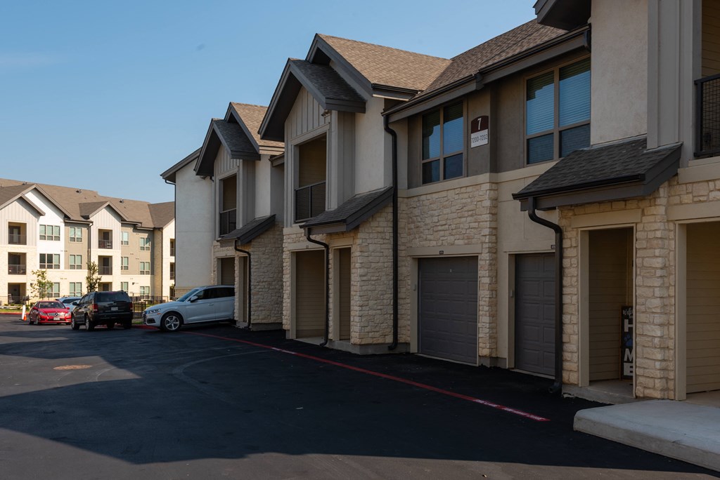 a row of townhouses with cars parked in a parking lot