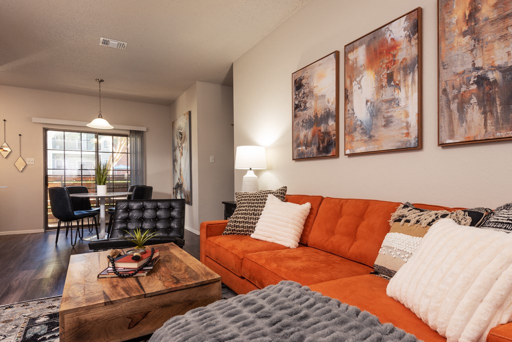 a living room with an orange couch and a coffee table