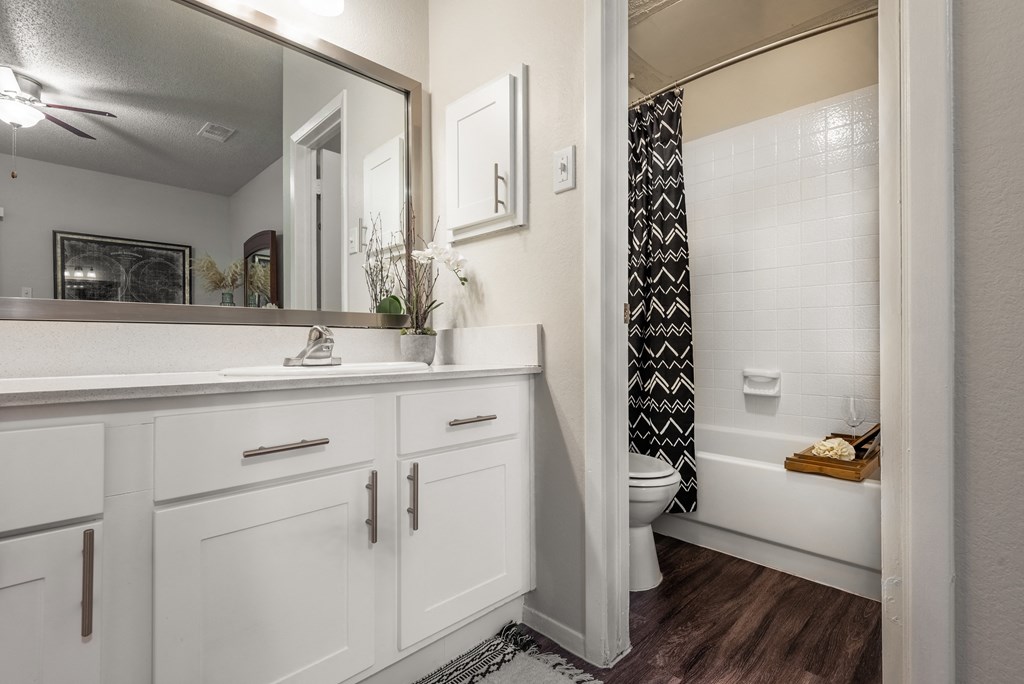 a bathroom with white cabinets and a shower and a toilet