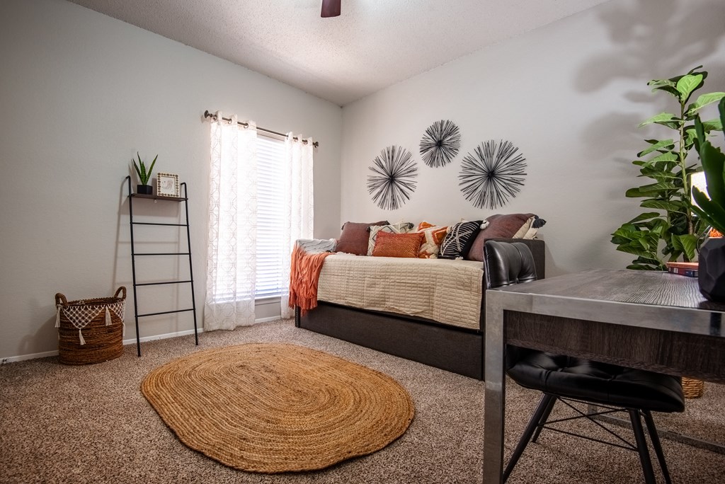 a bedroom with a bed and a desk and a table