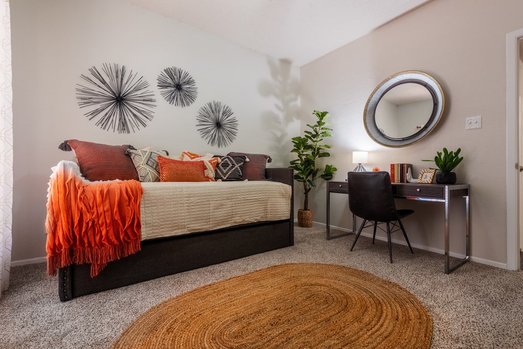 a bedroom with a bed and a desk with a mirror