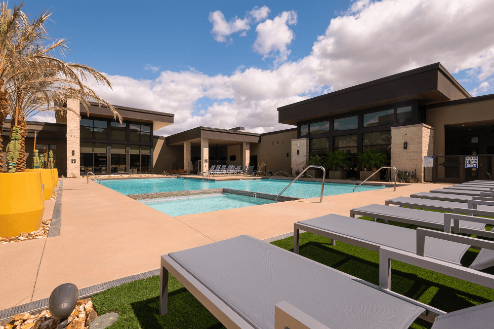pool with chairs in the foreground at escape at arrowhead's apartments in glendale, az