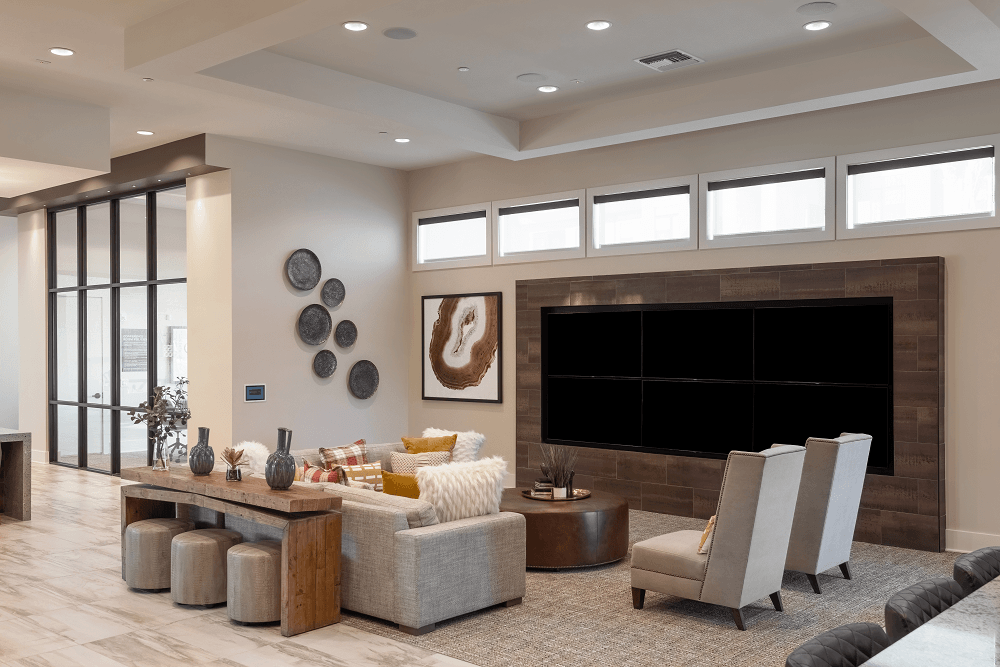 a living room with a large tv and a table and chairs