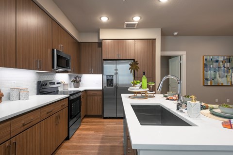 A modern kitchen with wooden cabinets and stainless steel appliances.