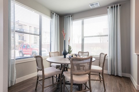 A dining room with a table and chairs.