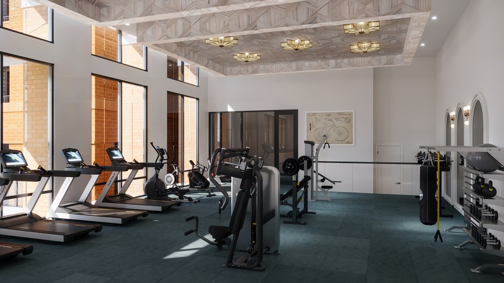 A well-lit gym with various exercise equipment.