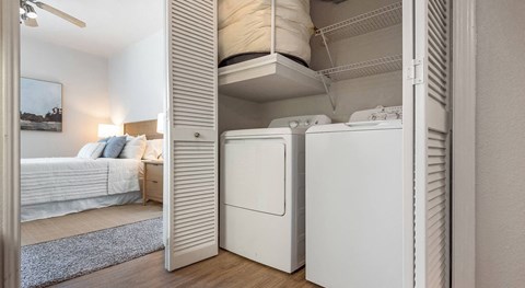 a bedroom with a bed and a washer and dryer