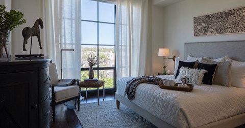 a bedroom with a bed and a dresser and a window