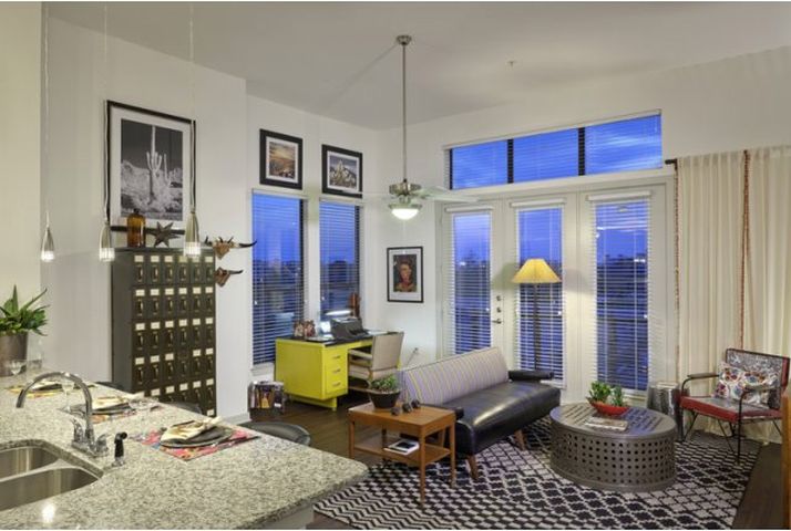 a living room with a couch a table and some windows