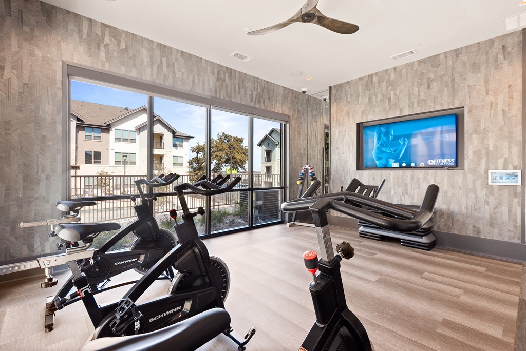 exercise room with amenities at ironridge at hill country village apartments