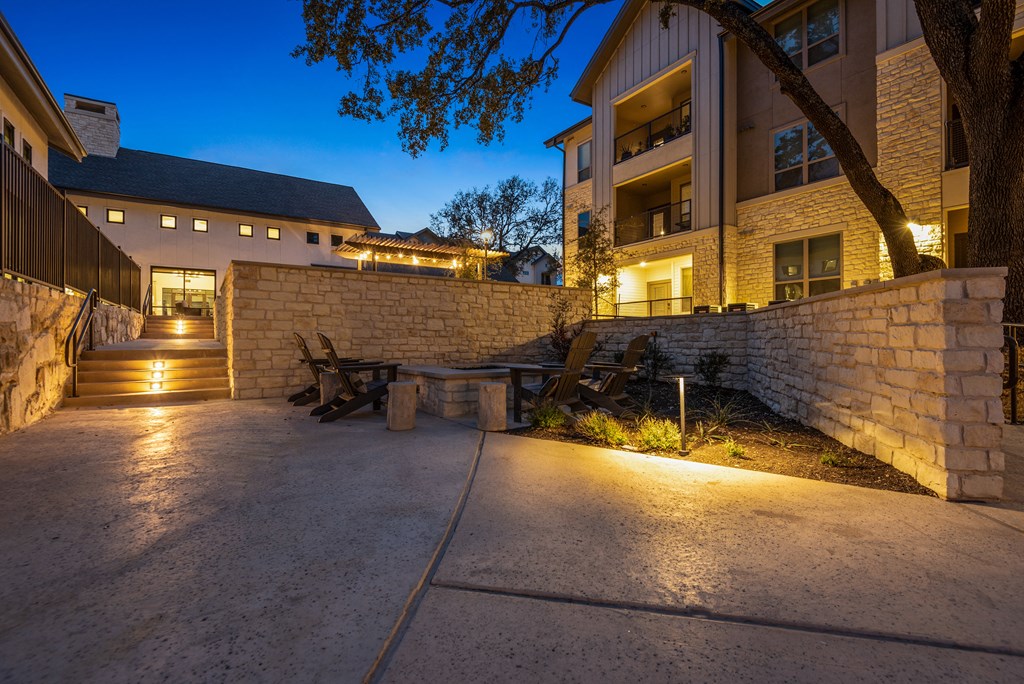 the courtyard at night with a picnic table in front of a building