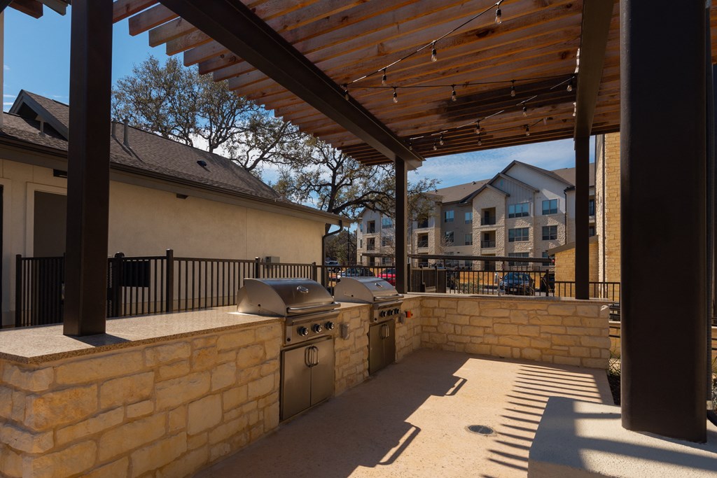 a patio with a barbecue grill and a pergola