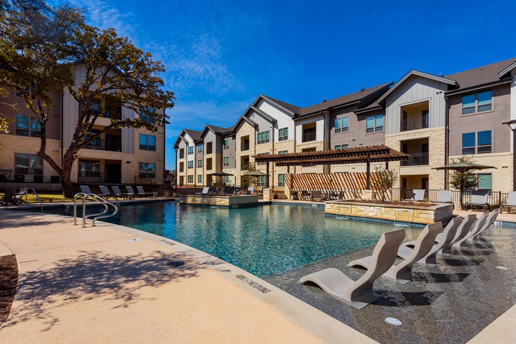 outdoor pool with lounge chairs at ironridge apartments