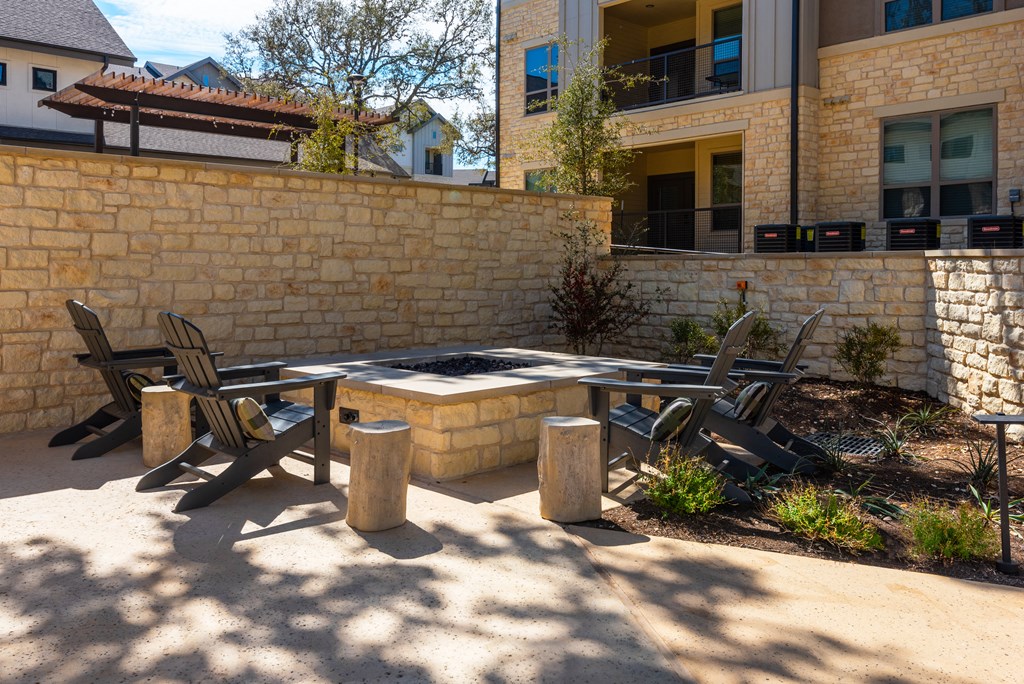 a patio with a table and chairs and a fire pit