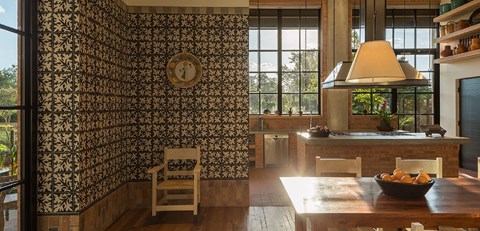 A kitchen with a table and chairs in front of a wallpapered wall.