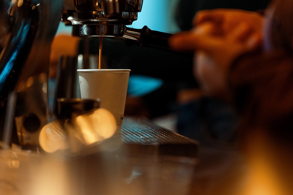 A person is making a cup of coffee using a coffee machine.