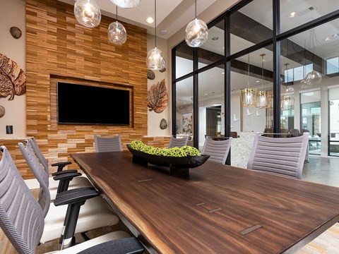 a dining room with a wooden table with a bowl of fruit on it