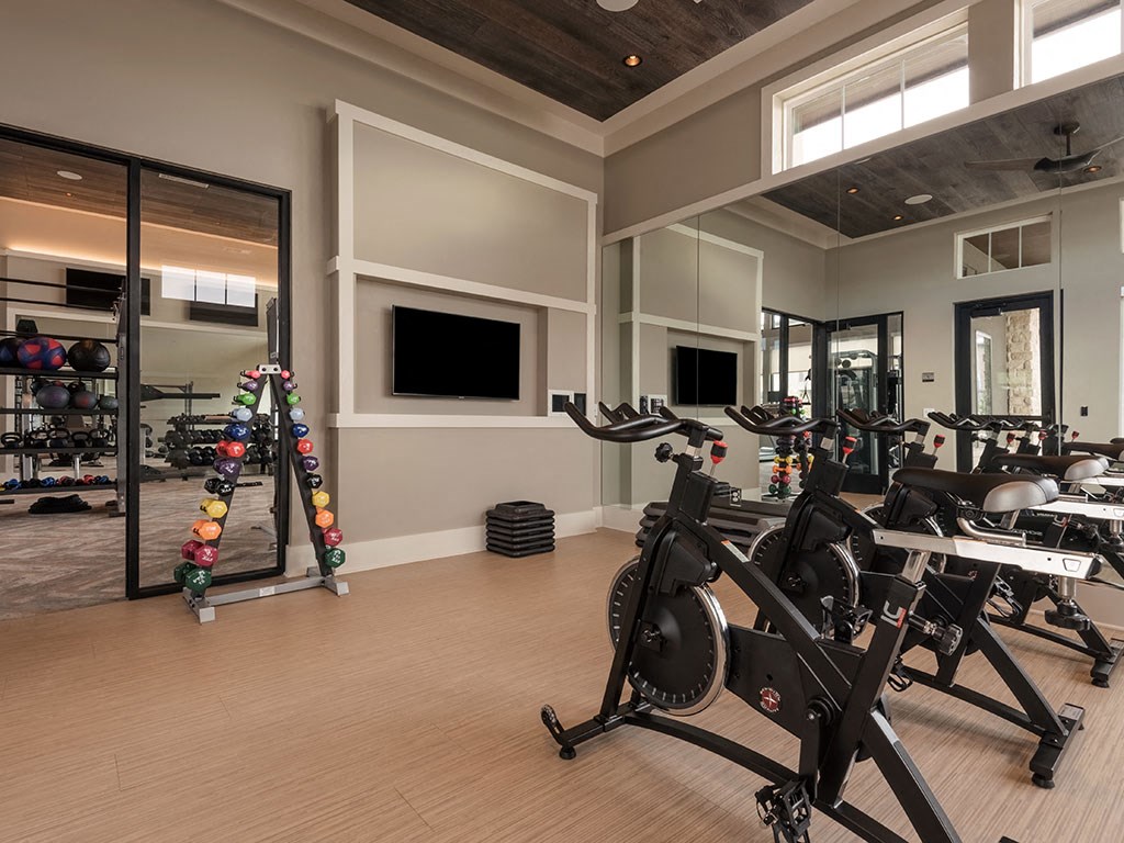a gym with a lot of exercise machines and a tv