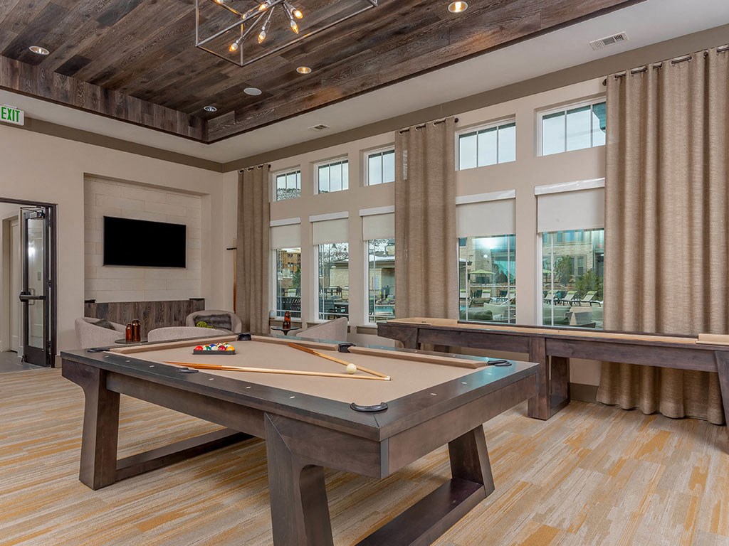 a games room with a pool table and a tv