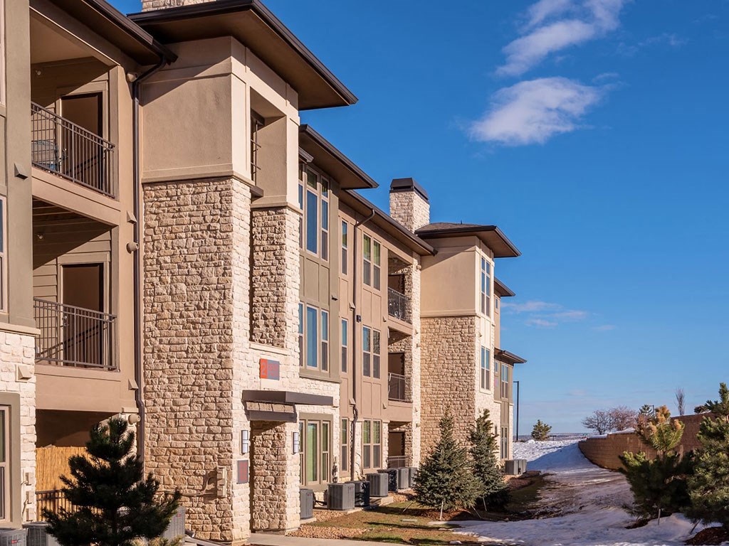 a large apartment building with a blue sky in the background