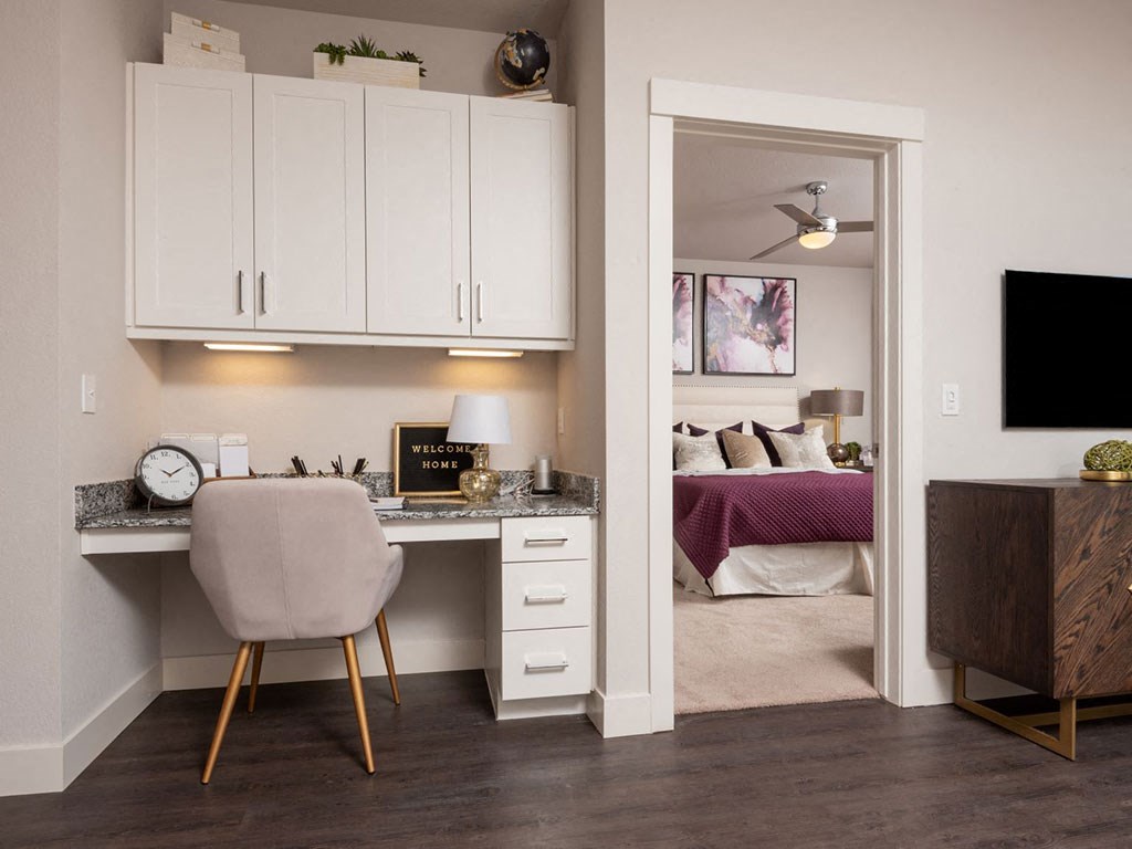 a bedroom with a desk with a chair and a bed