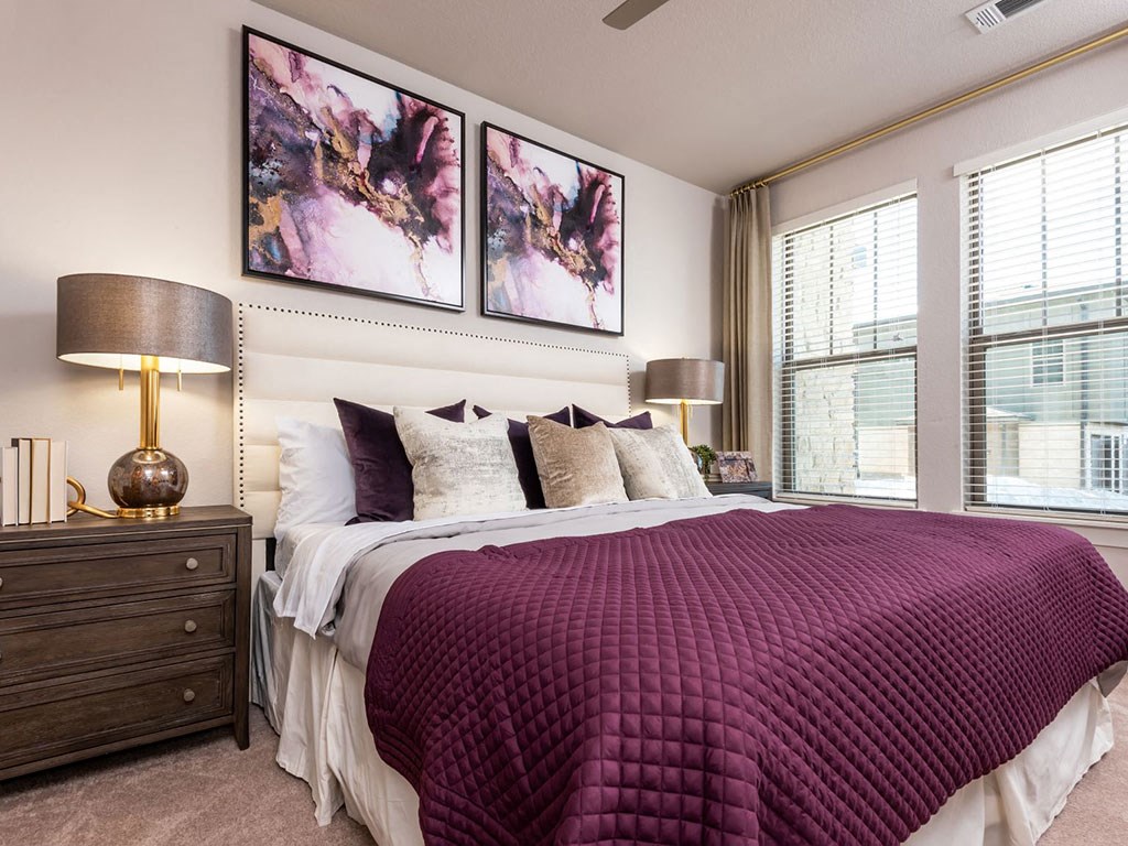 a bedroom with a bed and two windows