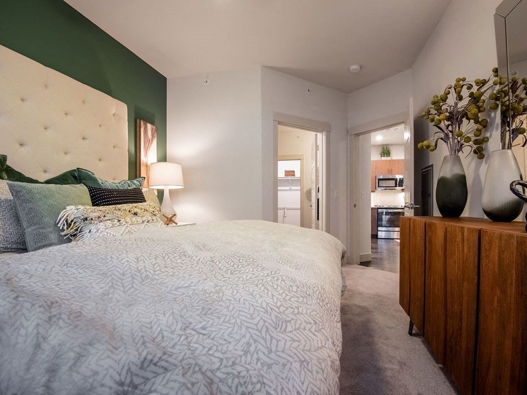 a bedroom with a white bed and a green wall