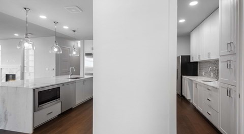 A modern kitchen with white cabinets and stainless steel appliances.