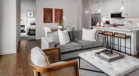 A modern living room with a grey sofa and a wooden chair.