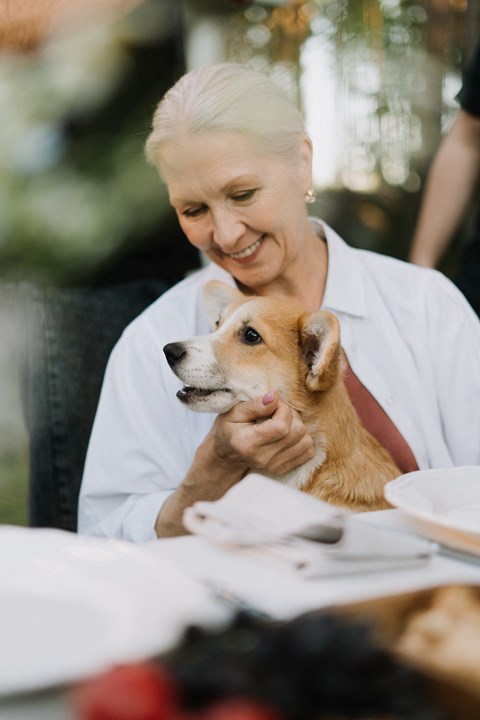 a woman sitting at a table with a dog