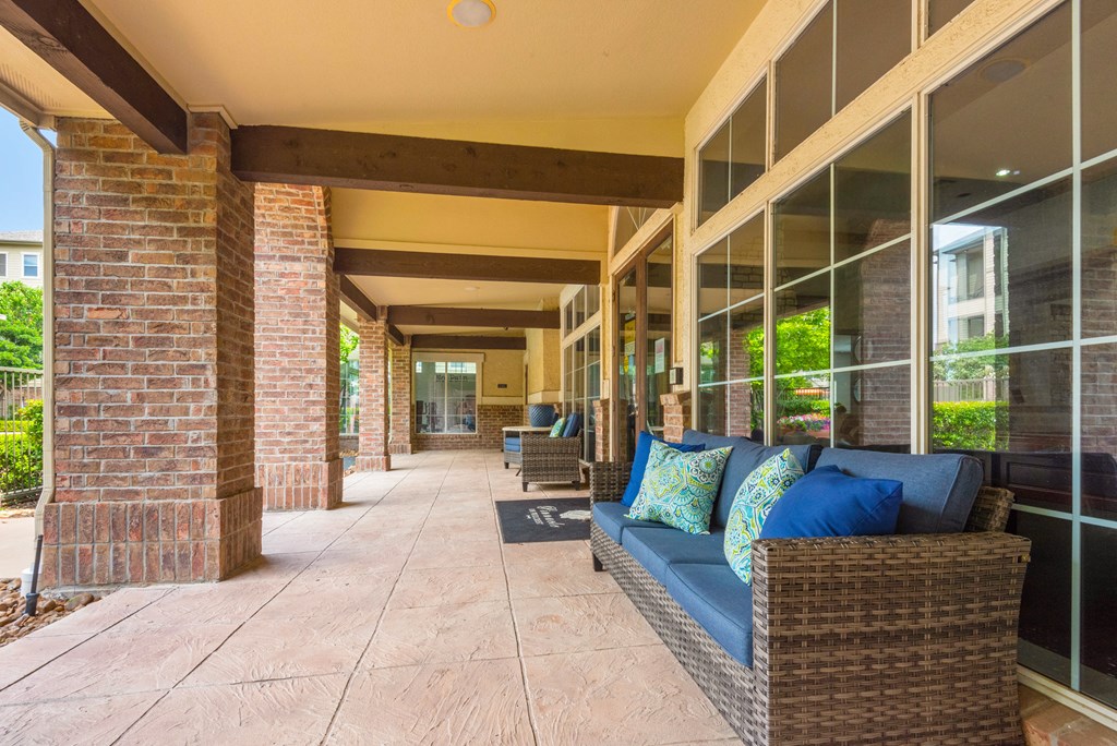 a long porch with a couch and pillows on it