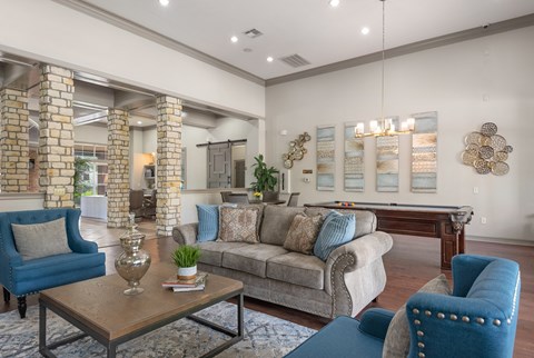 a living room with couches and chairs and a pool table