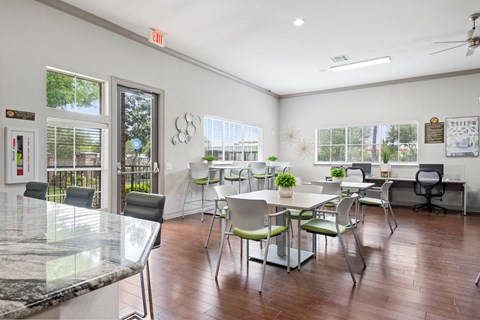 a dining room with tables and chairs and a bar and windows