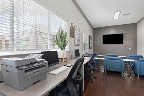 a office with a printer and a table with chairs and a computer