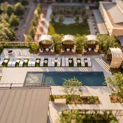 A modern building with a pool in the middle of the courtyard.